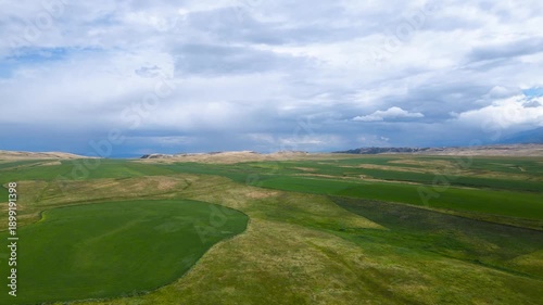 green fields at the foot of the mountains. a mountain plateau