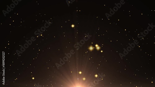 Brilliant golden particulate matter streams upward from a bright central light source against a deep dark background suggesting magic or celebration.