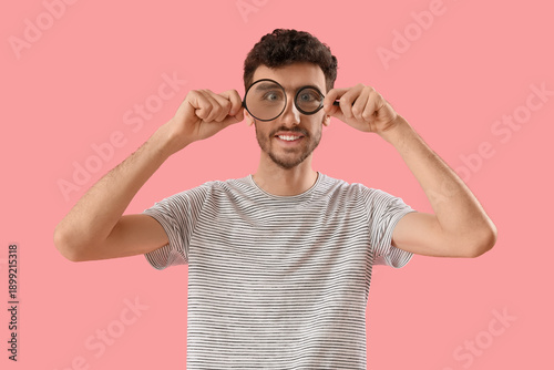 Young man with magnifiers o...