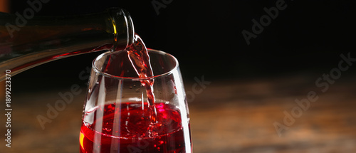 Pouring of red wine into gl...