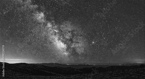 A serene night sky with the Milky Way galaxy visible over a dark landscape viewed from a low vantage point