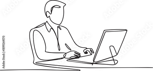 Man working on laptop with focused expression while sitting at desk in office environment from side view