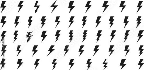 A collection of black lightning bolts arranged in a grid pattern on a plain surface from a direct viewpoint