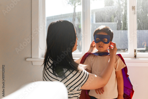 Asian mum help young son put on his mask