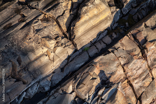 The texture of a stone cliff illuminated by the setting sun