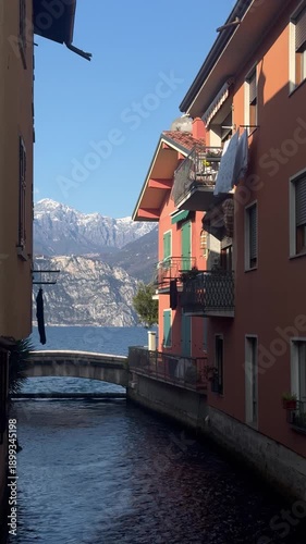 Cozy picturesque village on Lake Garda with a narrow stream flowing between houses, Italian vibe, charming waterfront town surrounded by nature.
