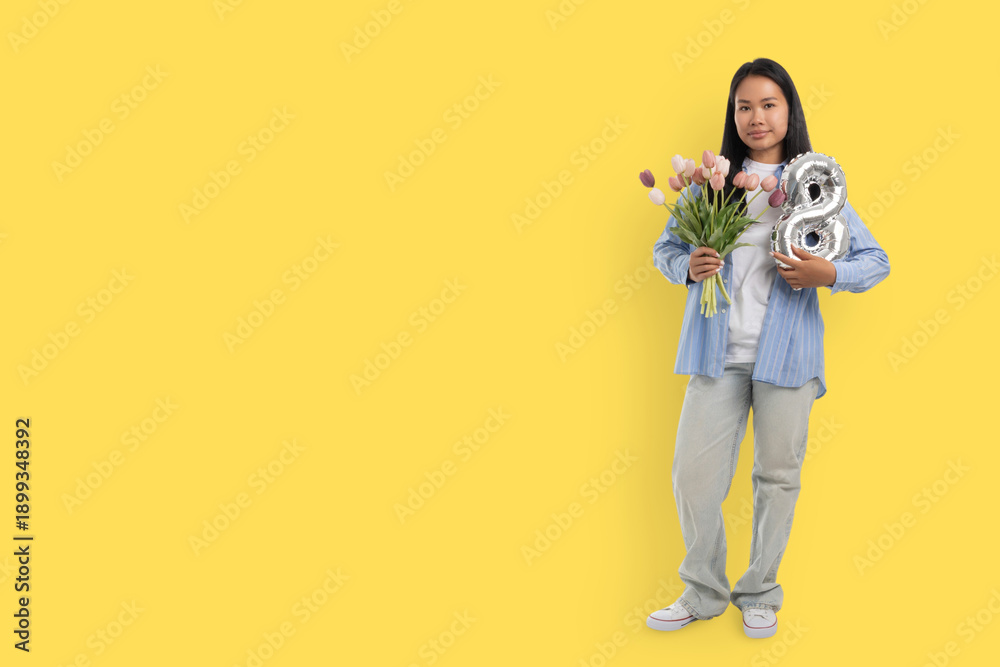 Naklejka premium Young woman holds flowers and balloons for Women's Day