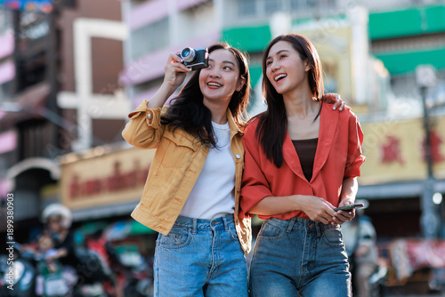 Foto Young asian women friends traveling, exploring city street