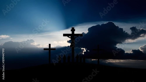 Silhouette of Jesus Christ on cross with followers on hilltop at sunset