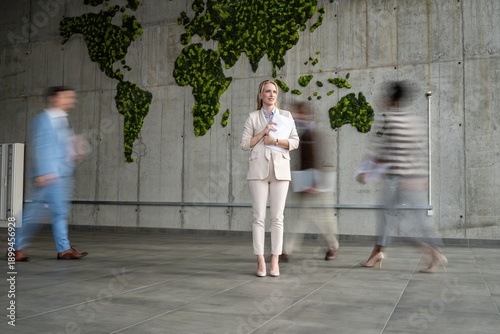Fotografía Businesswoman standing still amidst global corporate motion