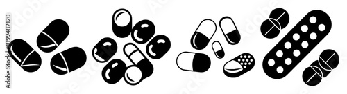 Assortment of black and white pills and capsules scattered on white background for medical health concept
