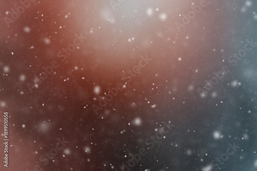 Blurred bokeh image capturing delicate falling snowflakes against a softly lit gradient background. The atmospheric composition creates a tranquil and serene winter scene.