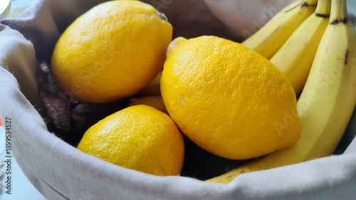 Fresh ripe lemons and yellow bananas in a bowl