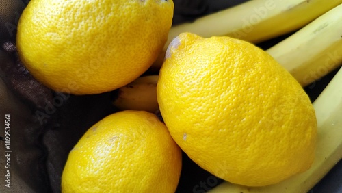 Fresh ripe lemons and yellow bananas in a bowl
