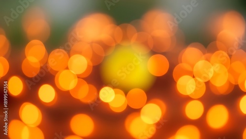 Orange bokeh lights on dark background with green and yellow hues orange lights blurry yellow light green background