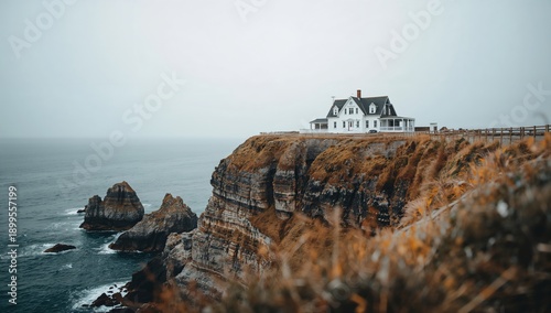 Houses on a Cliff Overlooking the Ocean With Green Grass and Distant Water Un...