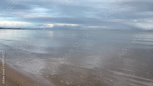The seashore in cloudy weather, calm water, calm water in the evening