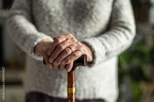 Obraz na plátně Close-up shot of senior woman's hands holding walking stick