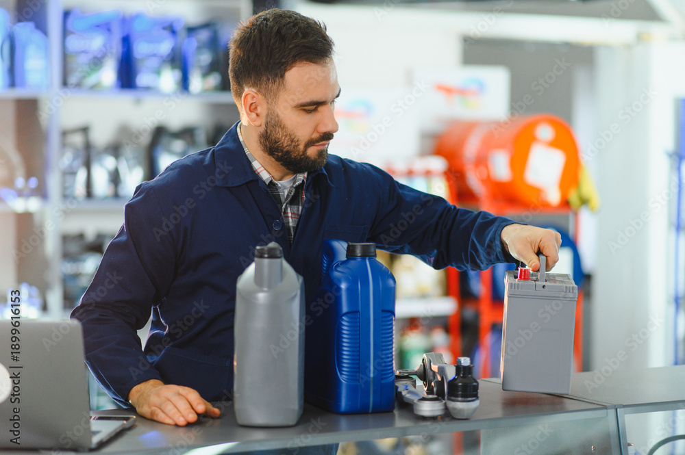 Ταπετσαρία Mechanic working in auto parts store selecting car battery