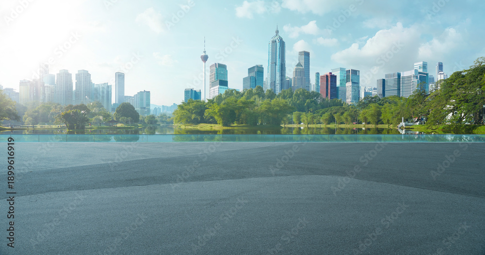 Fototapeta premium Kuala lumpur city skyline and park lake view with empty road