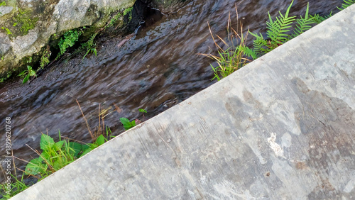 Clear Water Flowing Through a Concrete Drainage Ditch