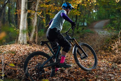 Autumn Mountain Bike Ride Through Leafy Trail With Rider Wearing Helmet And Protective Gear