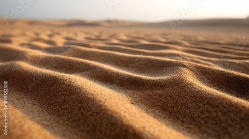 Close up of textured sand dunes with intricate wind blown ripples under soft warm sunlight creating a serene desert landscape