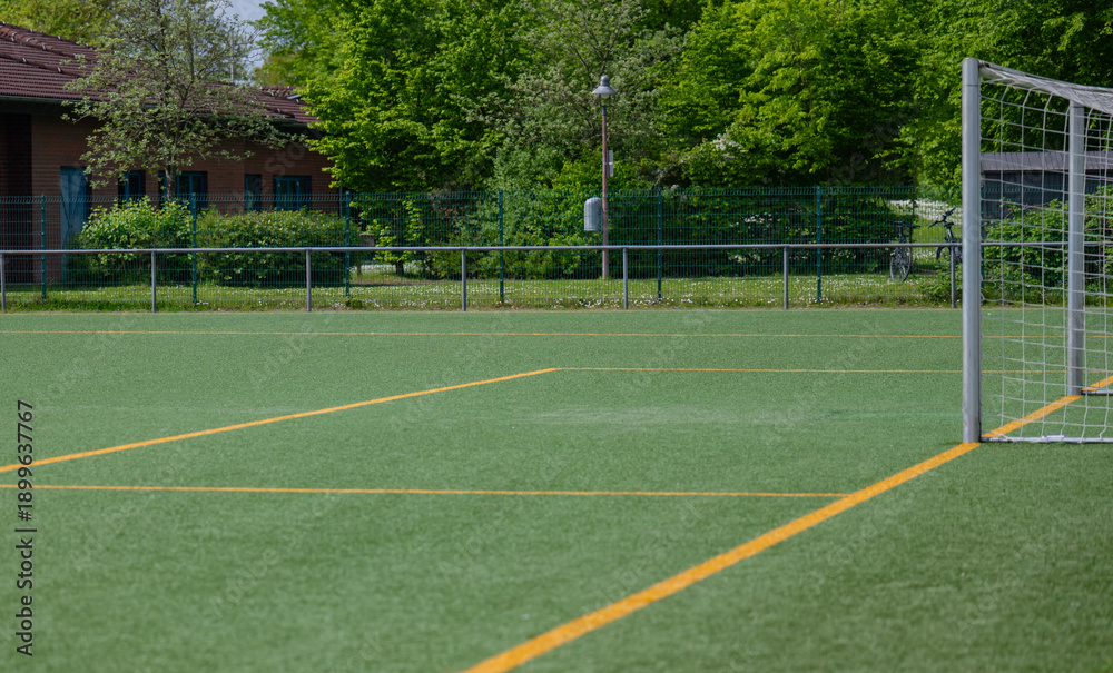 Fototapeta premium Nahaufnahme eines Fußballfeldes mit Kunstrasen und orangefarbenen Streifen