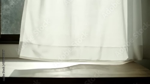 White Sheer Curtain Blowing in the Wind by a Sunny Window