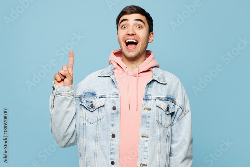 Foto Young smart proactive man he wears pink hoody denim casual clothes holding index finger up with great new idea isolated on plain pastel light blue cyan background studio portrait