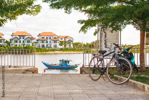 Wallpaper Mural Blue old wooden boat on river with pier, trees, railing, and old bicycle, private houses in background Torontodigital.ca