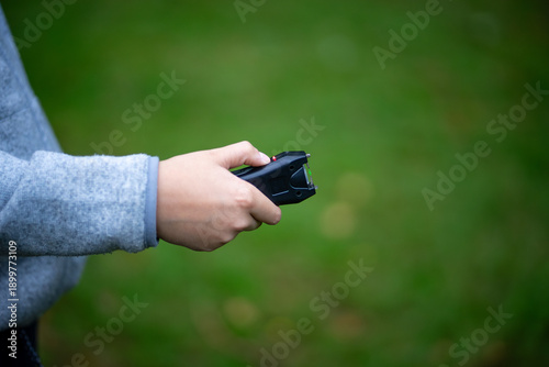 Canvas-taulu Compact stun gun in the hands of a child