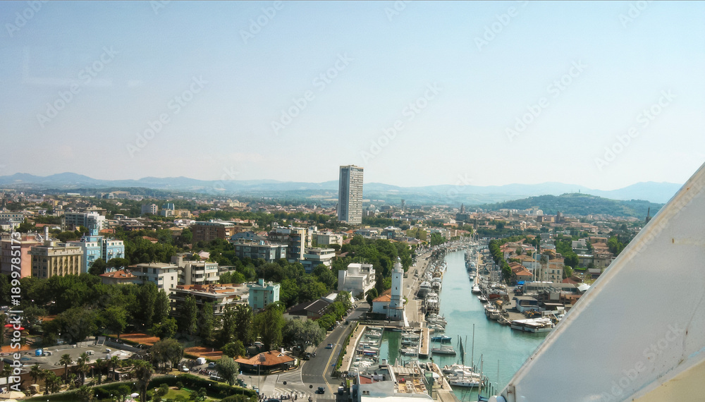 Fototapeta premium Aerial view of Rimini cityscape with marina and mountains in the background, Italy