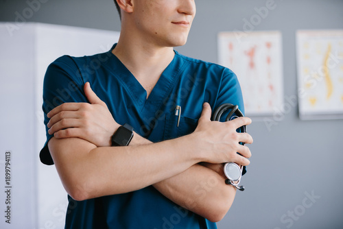 Φωτογραφία Young doctor standing with stethoscope in office