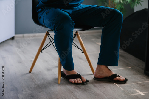 Foto Healthcare professional relaxing in scrubs and flip-flops