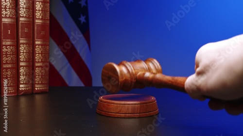 Courtroom gavel resting on a table near legal books and an American flag at a law office in a quiet setting