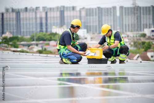 Engineers inspecting solar panels on a rooftop