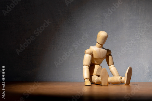 фотографія A wooden doll sits slumped in a defeated posture