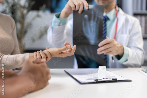Schilderij op canvas Doctor is diagnosing a patient's arm and wrist pain in an examination room