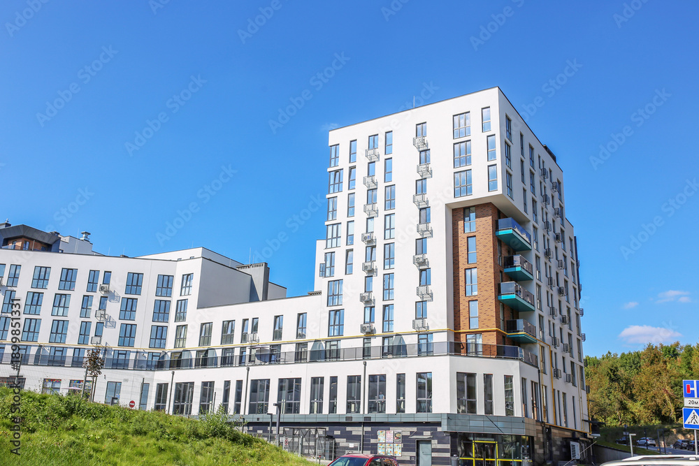 Obraz premium Modern White Apartment Complex with Blue Balconies