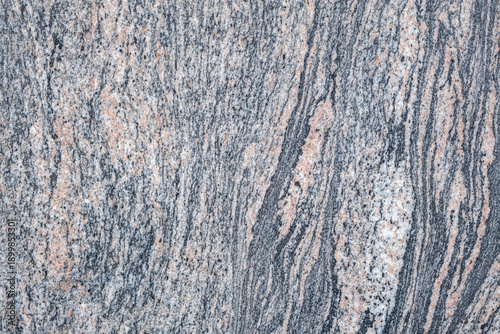 beautiful bright granite. Polished granite structure with veins and stripes. Bright gray, pink and yellow stone structure. Marble background