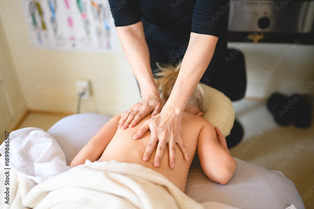 Fototapeta premium Professional masseur makes massage to a child girl
