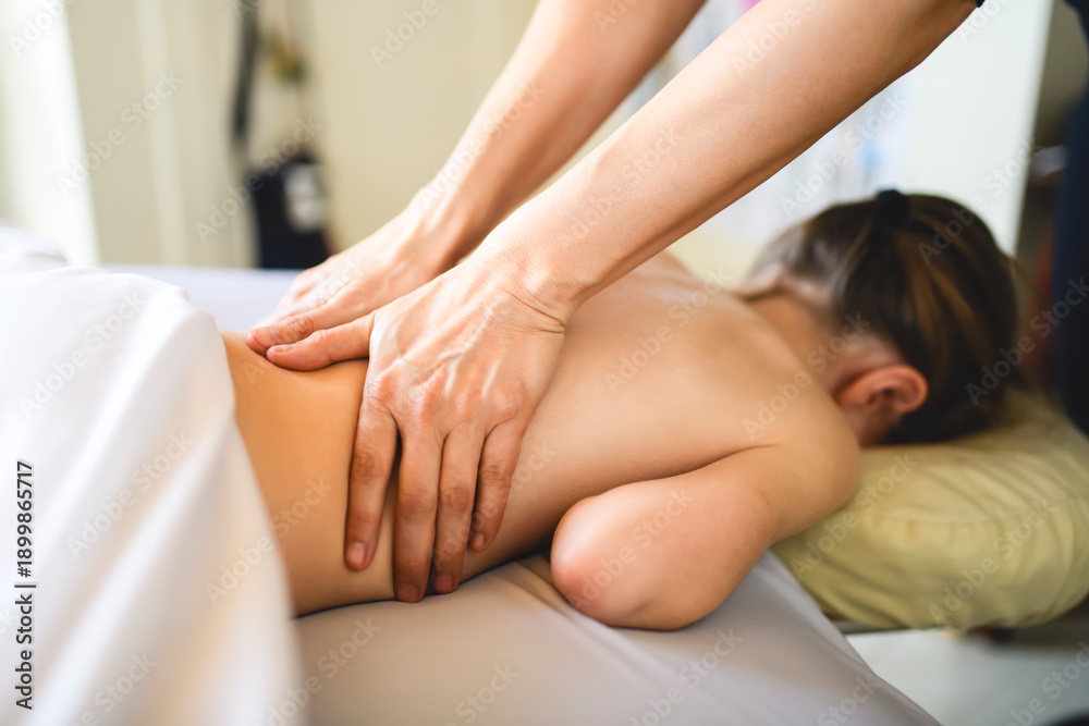 Fototapeta premium Professional masseur makes massage to a child girl
