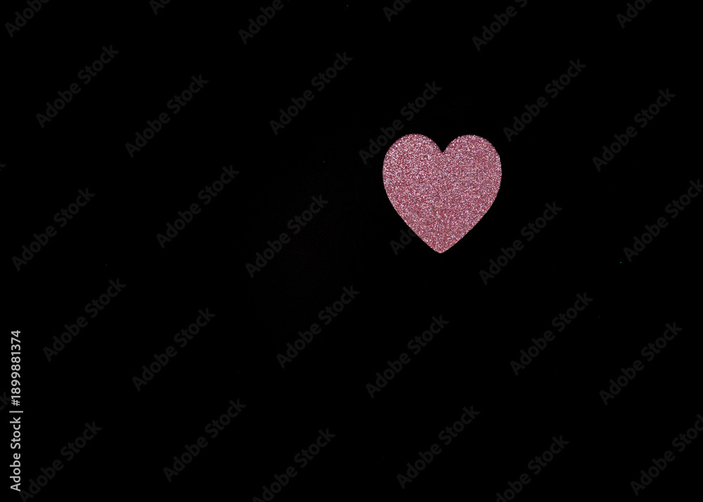 Obraz premium Single pink glitter heart placed on black background with large copy space. Minimal composition representing romance, tenderness and emotional connection.
