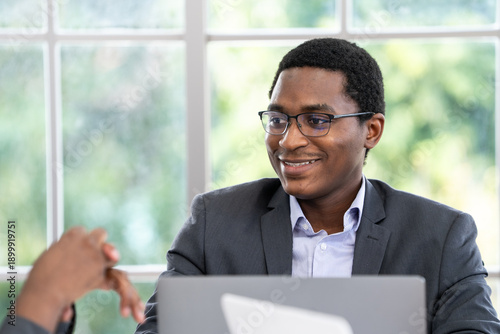 black business man smiling while working at laptop