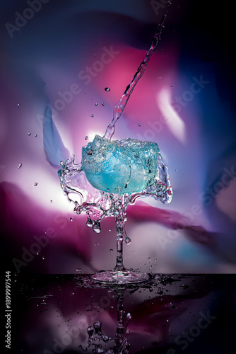 Alcohol is poured into a glass of blue cocktail