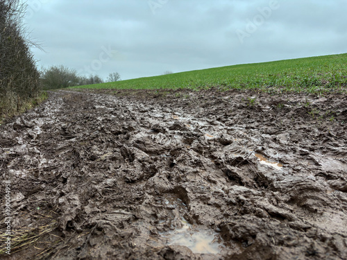 A muddy public footpath in the countryside in winter