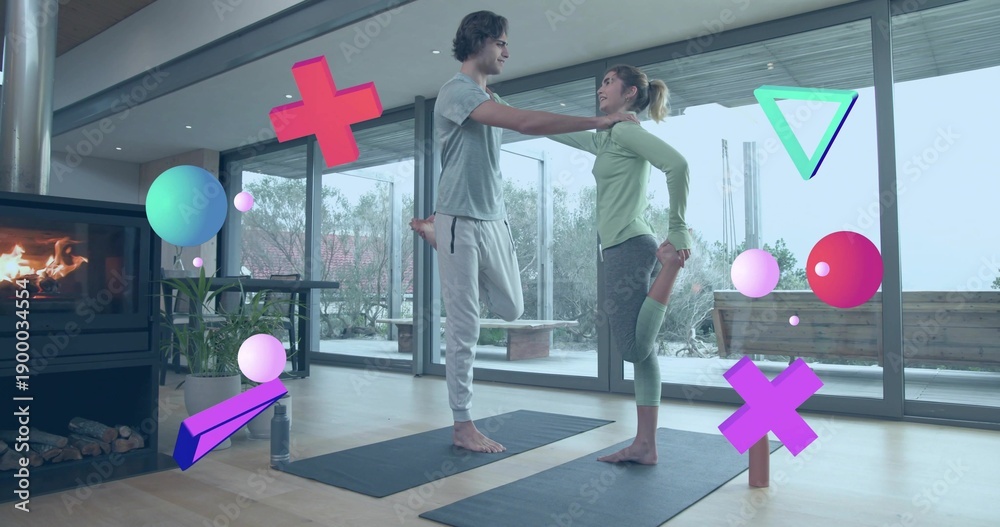 Fototapeta premium Practicing two women balancing on mats in living room, in athletic wear with floating AR shapes