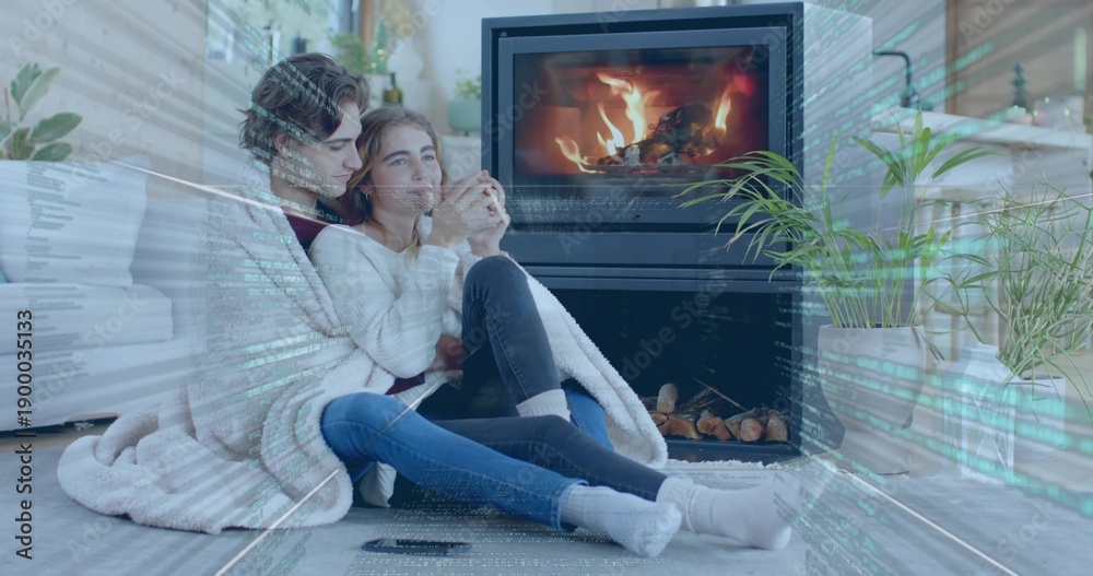 Obraz premium Cuddling two women in knit sweaters, jeans, under blanket in living room holding mug near fireplace
