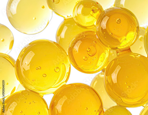 Abstract close-up of vibrant yellow oil or gel spheres against a dark background.